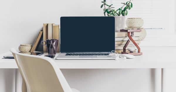 Home office desk, chair, laptop, and plants