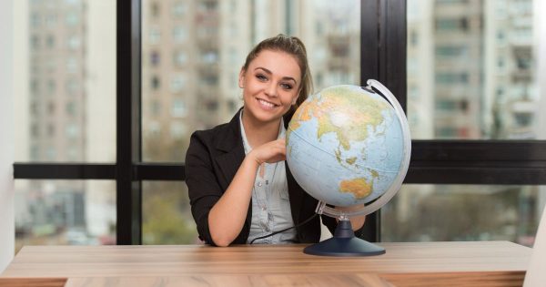Woman sitting at a desk with a globe